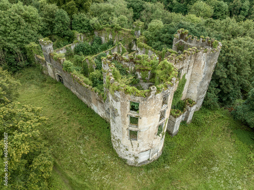 Aerial view of ruined and overgrown Buttevant or Barry's castle on the Awbeg river in County Cork Ireland with large circular towers 