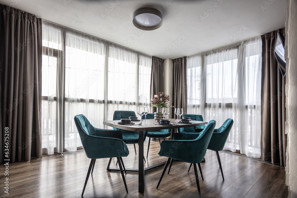 Dining room with wooden table and blue chairs floor in modern apartment Dining room with wooden table and blue chairs floor in modern apartment