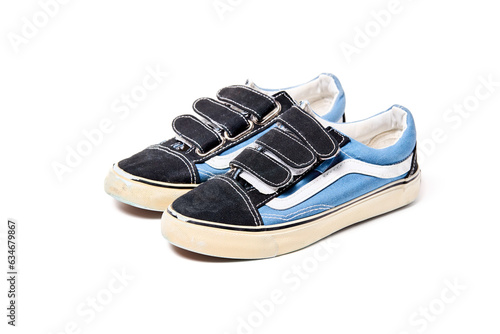 Used blue pair of baby sneakers isolated on white background three quarter view.
