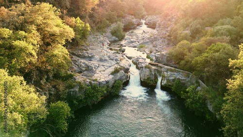 Spectacular Sunset Aerial Footage of Gole Alcantara River Waterfalls and Forest | Volcanic Rock Valley in Sicily countryside near Taormina | Scenic Nature, Italian Golden Hour Views photo