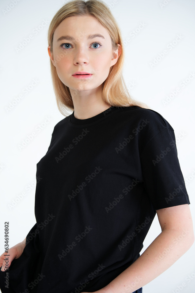 Vertical portrait of young woman posing in black T-shirt on white background Vertical portrait of young woman posing in black T-shirt on white background