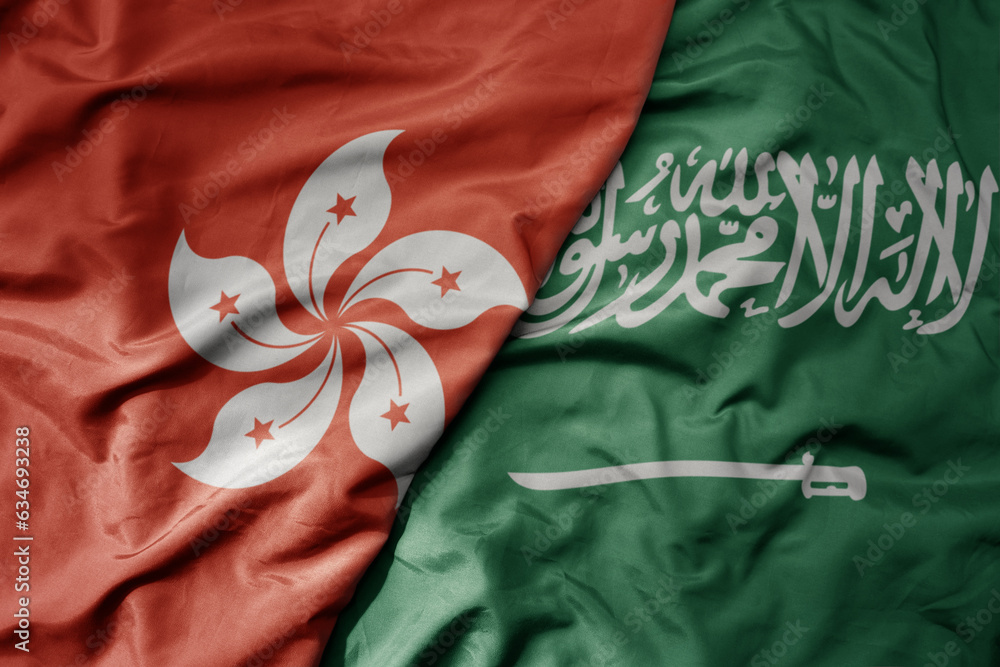big waving realistic national colorful flag of hong kong and national flag of saudi arabia .