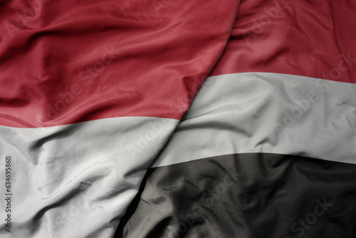 big waving realistic national colorful flag of indonesia and national flag of yemen .