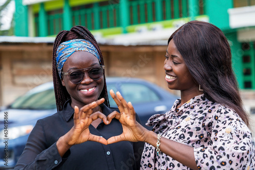 Two young African women making a heart with their hands