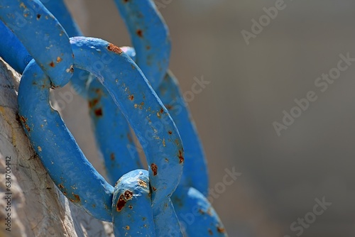 Stary niebieski łańcuch o grubych ogniwach na skale photo