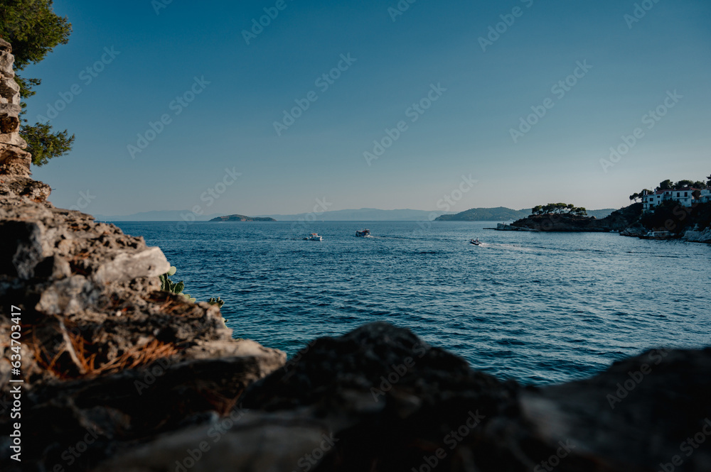 Evening view of the sea with small islands and boats on the coast of the Mediterranean sea, Greece, Skiathos Evening view of the sea with small islands and boats on the coast of the Mediterranean sea, Greece, Skiathos