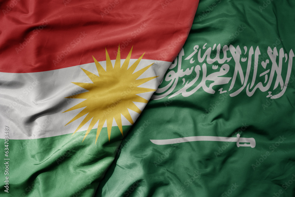 Φωτογραφία big waving realistic national colorful flag of kurdistan and national flag of saudi arabia