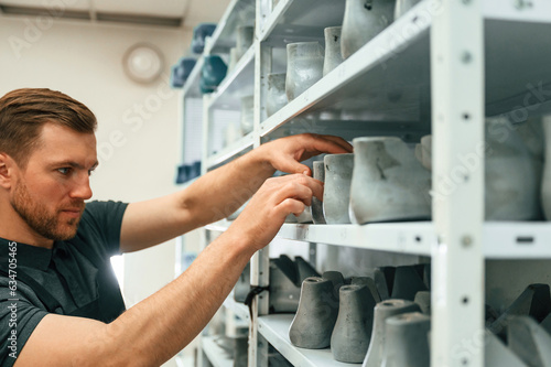 Raw shoe parts for the prosthesis. Man is choosing size