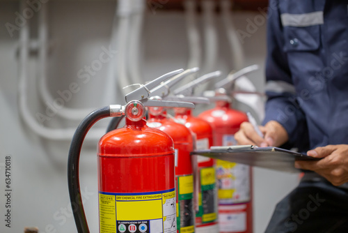 Engineer Professional are Checking A Fire Extinguisher Using Clipboard or checking Industrial fire control system.