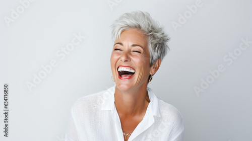 A close-up portrait of a beautiful senior woman with short gray hair, laughing and displaying her pristine teeth. This image was utilized for a dental advertisement. Gen AI © Nico Vincentini