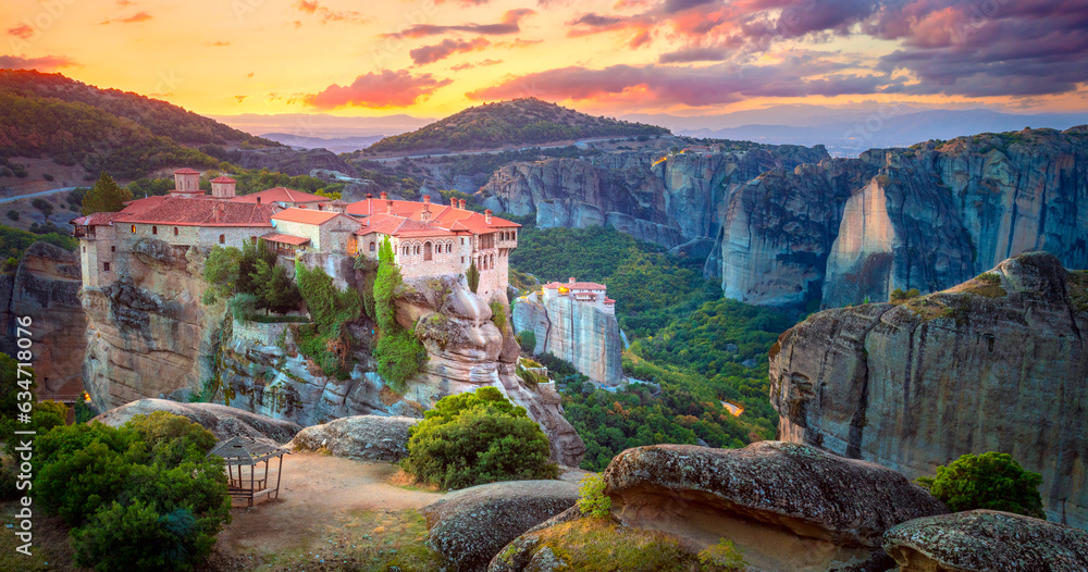 Panoramic view of Meteora. Greece, Meteora Monasteries. Panoramic view of the Holy Monastery of Varlaam, located on the edge of a high cliff. Beautiful sunrise. - obrazy, fototapety, plakaty 