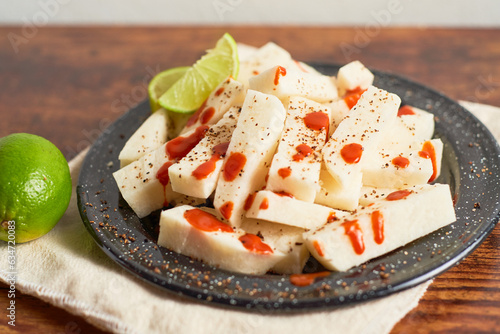 фотографія Mexican Traditional snack, jicama or yam bean, with chili, chamoy, sauce and lim