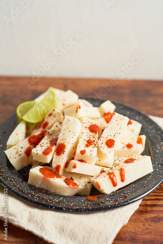 Mexican snack yam bean also called Jicama with chili powder and chamoy sauce