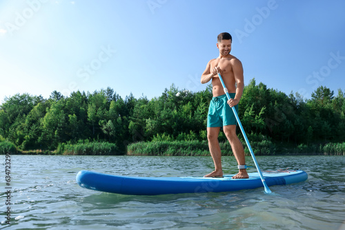 Man paddle boarding on SUP board in river © New Africa