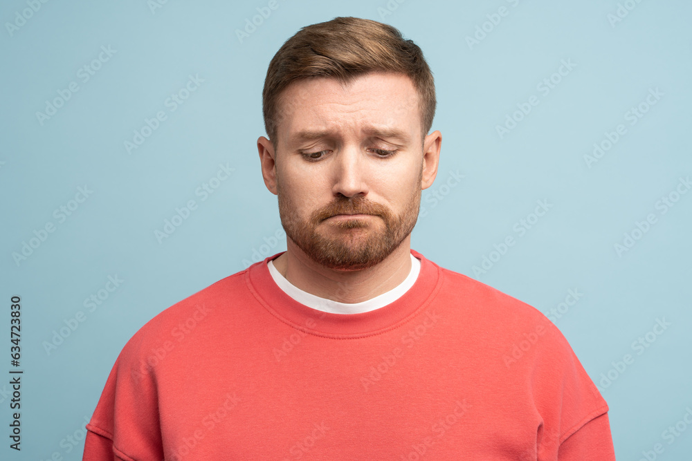 Frustrated unhappy man sadly looks down with upset expression isolated on studio wall. Concept of depression, disappointment. Regretful tired male with difficult trouble slack of money, broken heart Frustrated unhappy man sadly looks down with upset expression isolated on studio wall. Concept of depression, disappointment. Regretful tired male with difficult trouble slack of money, broken heart