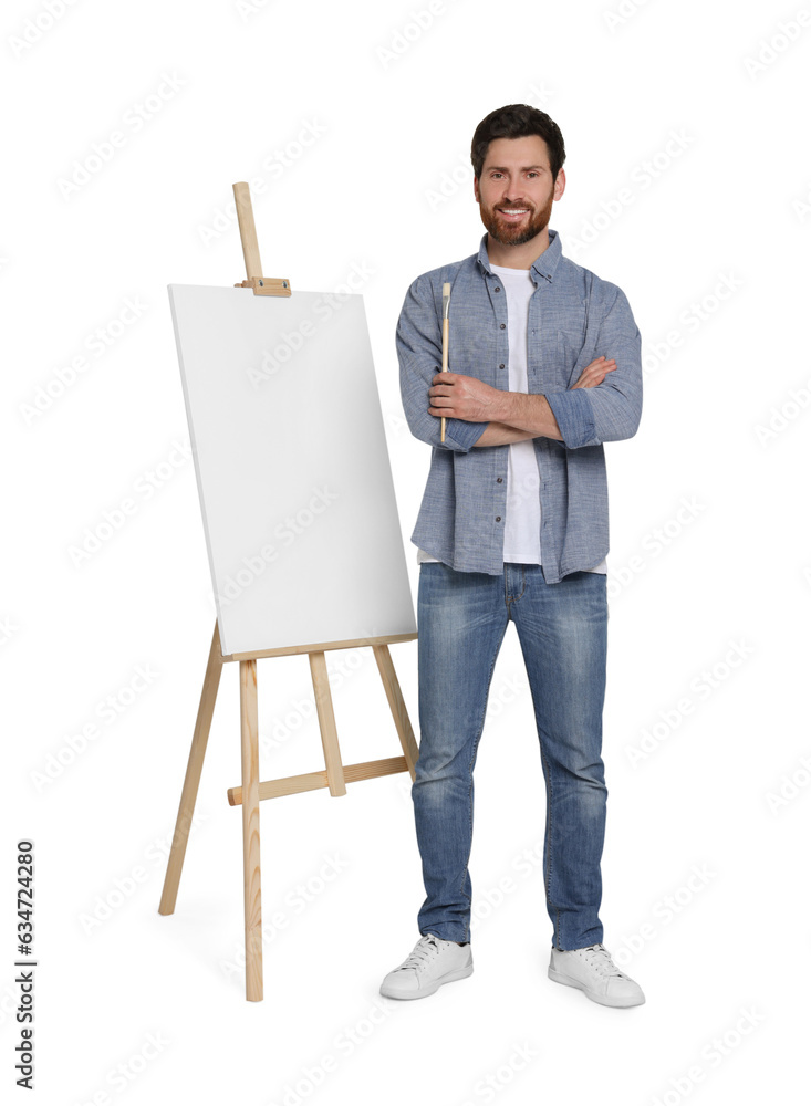 Happy man with brush near easel with canvas against white background. Creative hobby Happy man with brush near easel with canvas against white background. Creative hobby