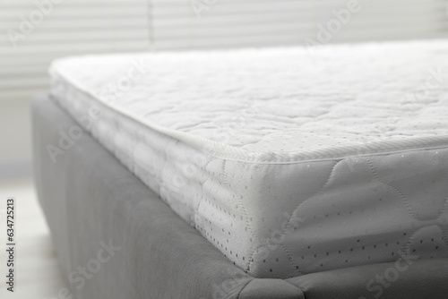 New light green mattress on gray bed indoors, closeup. Space for text