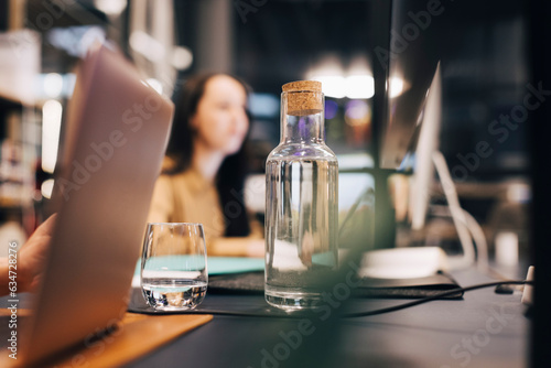 Water bottle and glass on desk at office photo