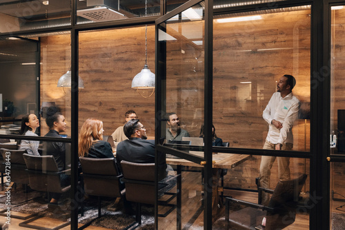 Wallpaper Mural Colleagues listening to confident businessman giving presentation in board room during meeting Torontodigital.ca
