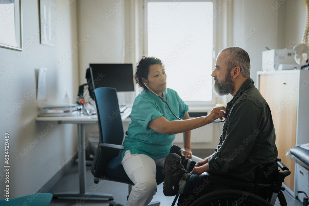 Female doctor examining mature man with disability in hospital Female doctor examining mature man with disability in hospital