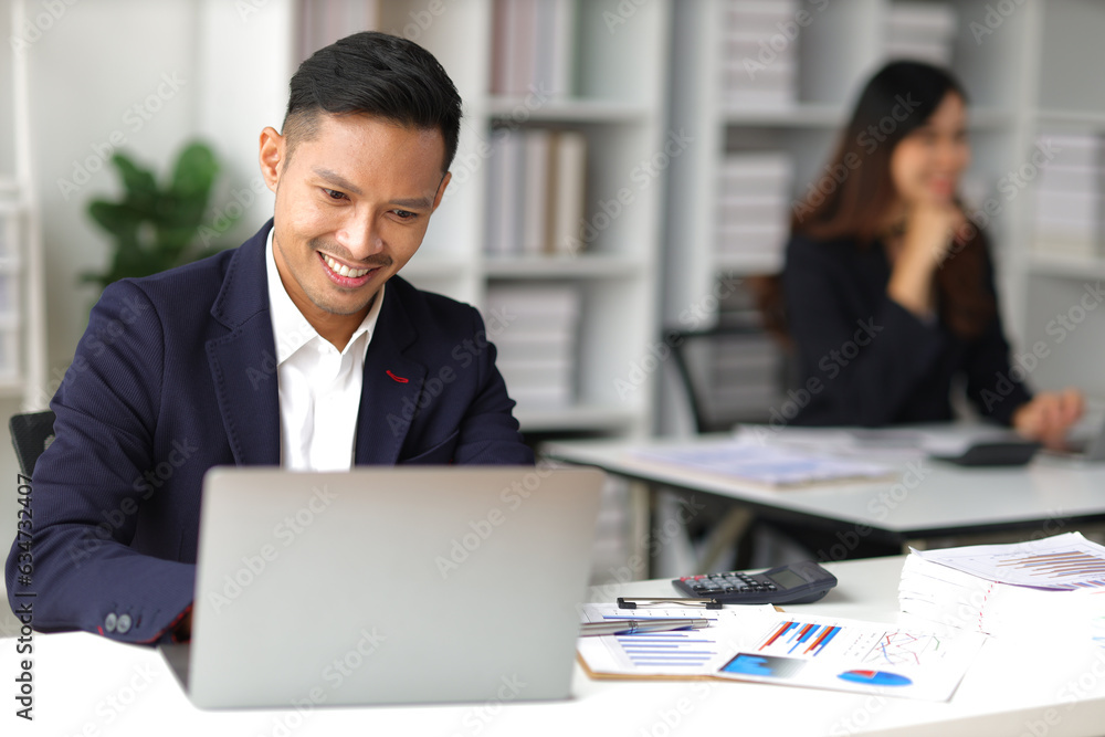 Middle-aged Asian businessman working on paperwork on the desk in the office. Middle-aged Asian businessman working on paperwork on the desk in the office.