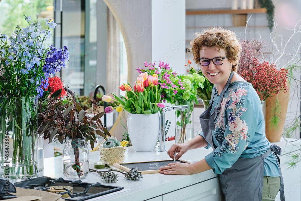 Positive mature woman working in floral shop Positive mature woman working in floral shop