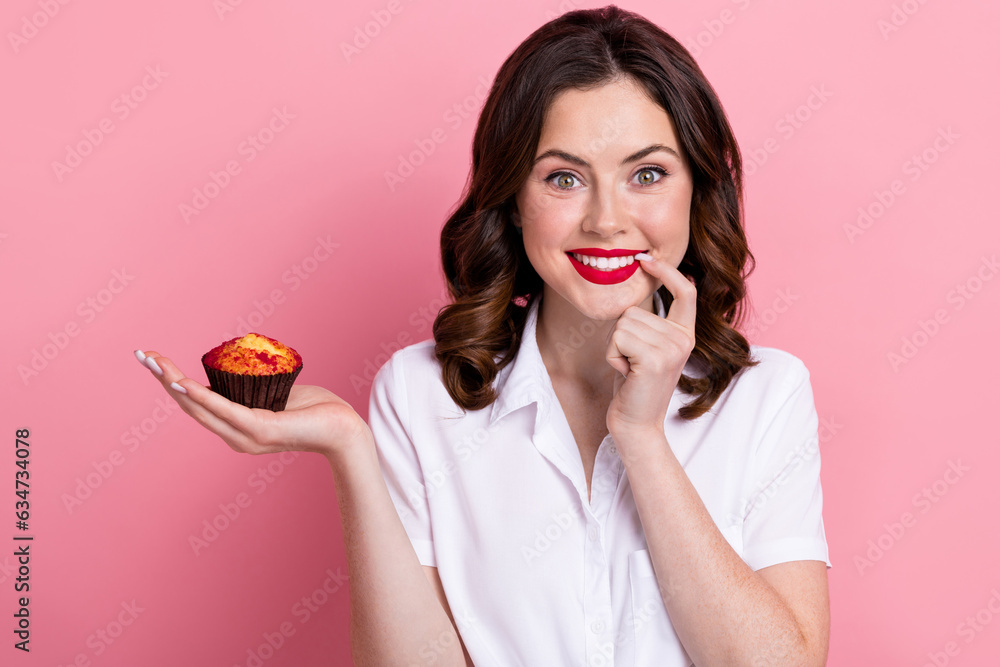 Photo of cute tricky woman dressed white shirt finger lips mouth holding hand arm small cupcake isolated pink color background Photo of cute tricky woman dressed white shirt finger lips mouth holding hand arm small cupcake isolated pink color background