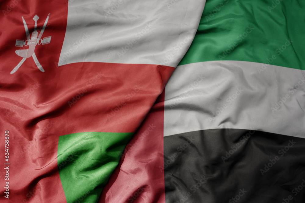 big waving realistic national colorful flag of oman and national flag of united arab emirates .