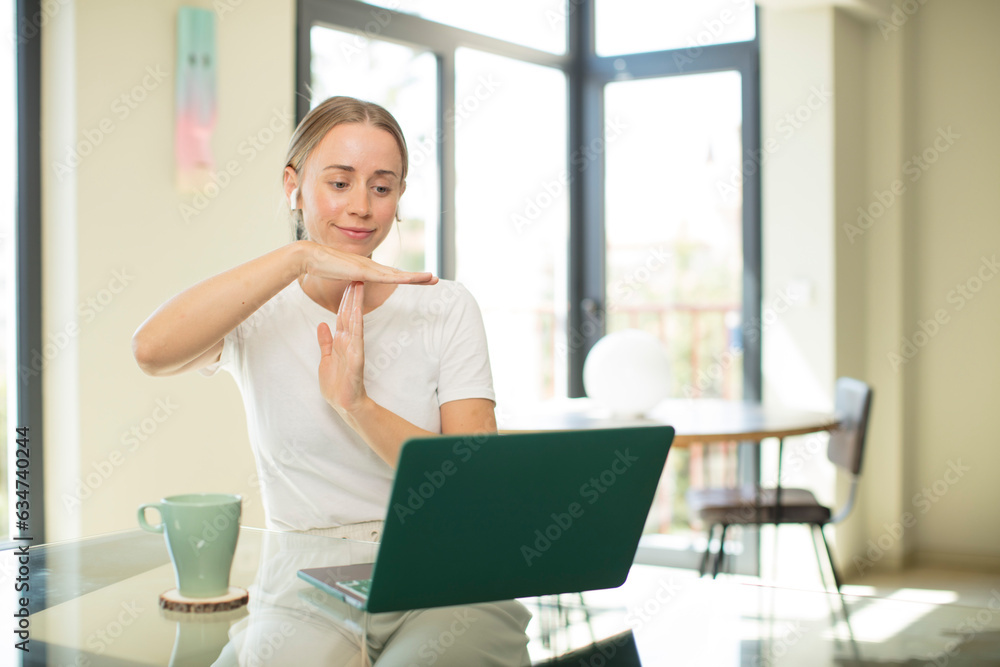caucasian pretty woman with a laptop looking serious, stern, angry and displeased, making time out sign caucasian pretty woman with a laptop looking serious, stern, angry and displeased, making time out sign