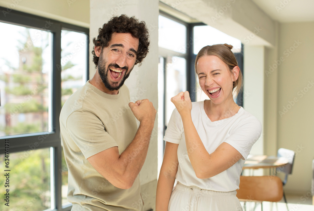 young adult couple feeling happy, satisfied and powerful, flexing fit and muscular biceps, looking strong after the gym young adult couple feeling happy, satisfied and powerful, flexing fit and muscular biceps, looking strong after the gym
