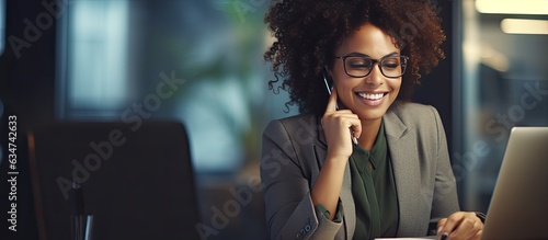 Fotografija African American businesswoman smiles while working speaking on the phone and ma