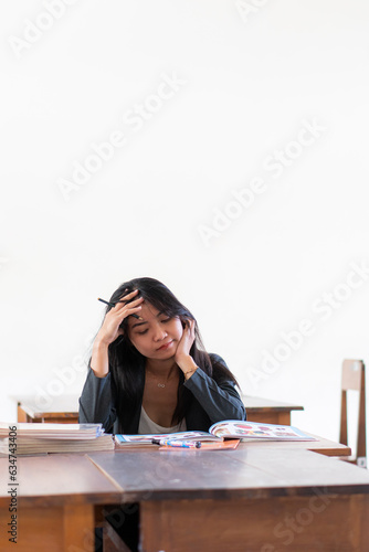 back to school with tired woman college students; portrait of exhausted woman students studying hard in college level education, fall or winter back to school concept; asian young adult woman model