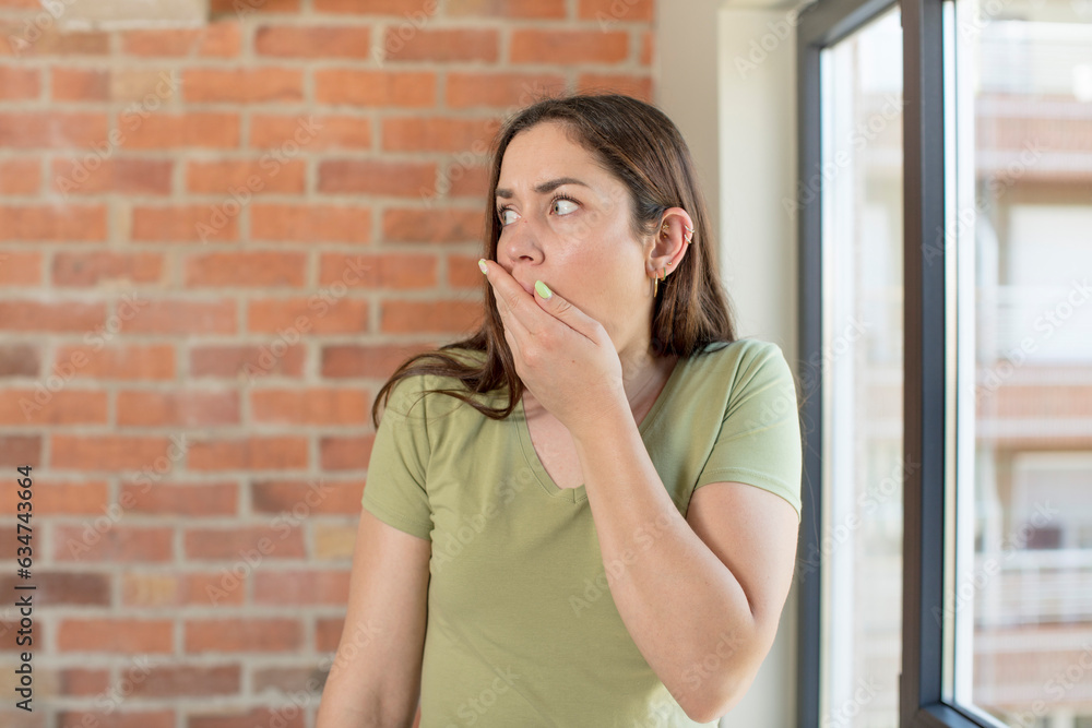 young adult pretty woman covering mouth with hands with a shocked, surprised expression, keeping a secret or saying oops young adult pretty woman covering mouth with hands with a shocked, surprised expression, keeping a secret or saying oops