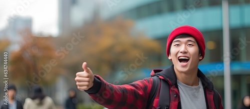 An enthusiastic Asian man showing empty copy space isolated on blue