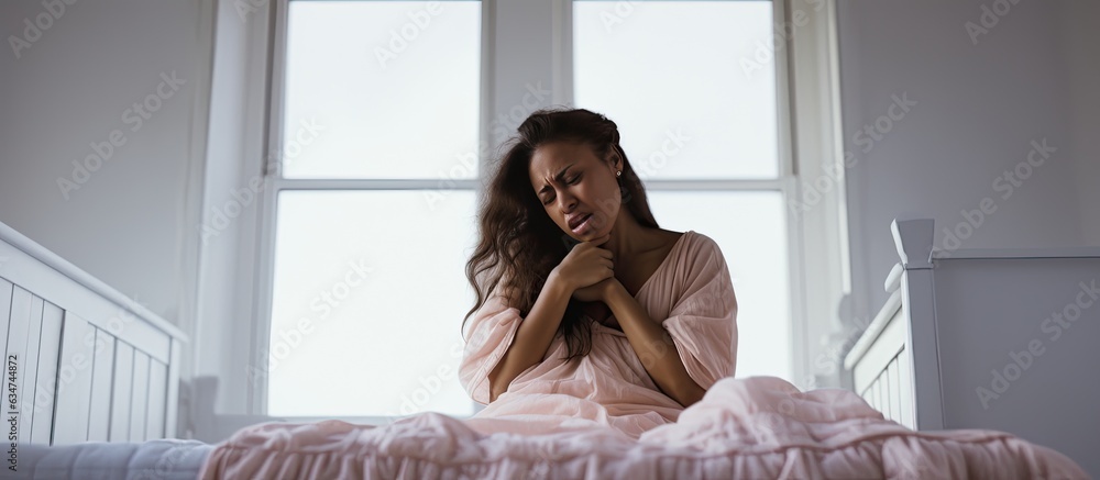 Fototapeta premium Emotional pregnant woman facing depression experiencing hormonal changes distressed and covering face in white bedroom