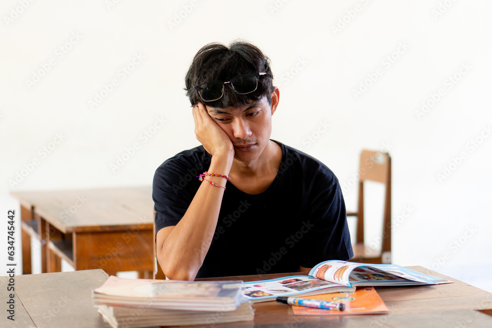 Overworked and tired high school student man studying feeling depressed and desperate Overworked and tired high school student man studying feeling depressed and desperate