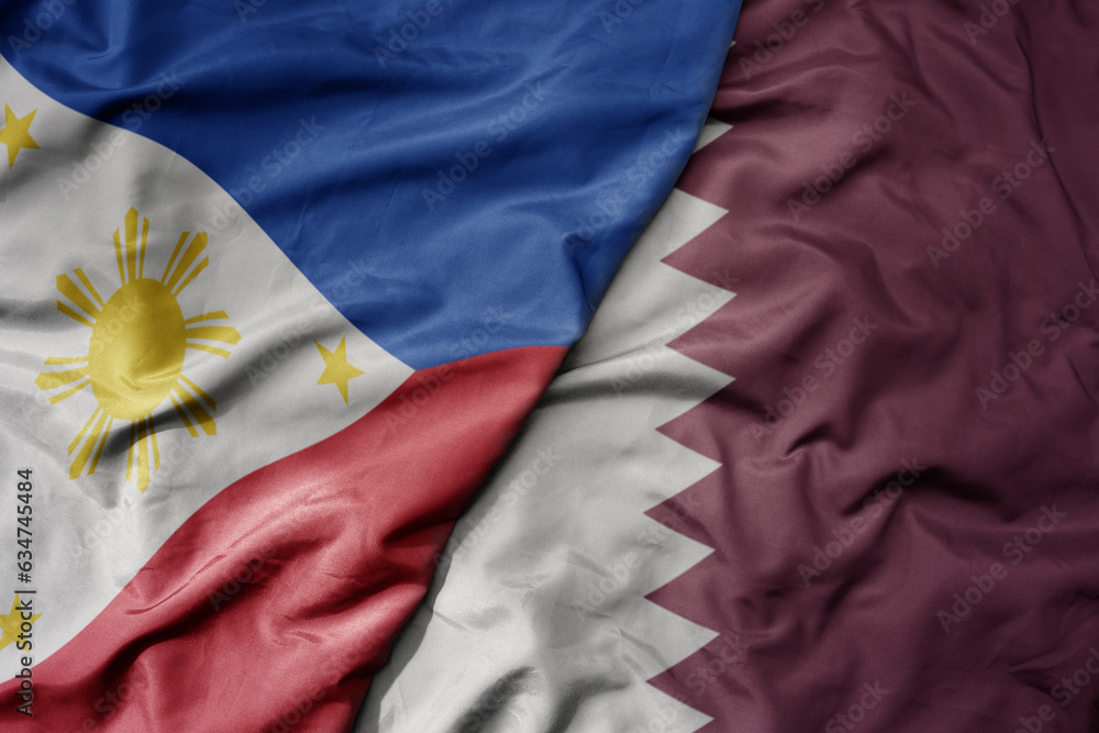 big waving realistic national colorful flag of philippines and national flag of qatar .