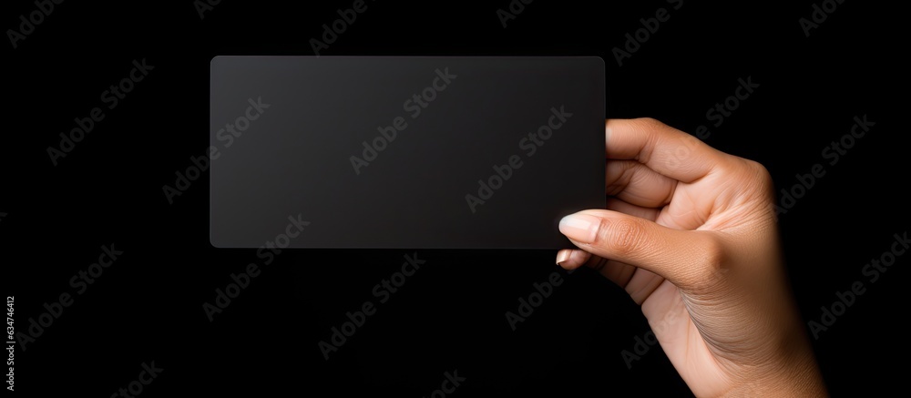 Caucasian woman s hand holds black business card on black background Symbolizes business and writing space Caucasian woman s hand holds black business card on black background Symbolizes business and writing space