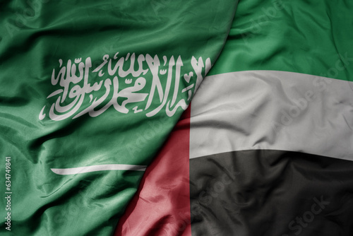 big waving realistic national colorful flag of saudi arabia and national flag of united arab emirates .