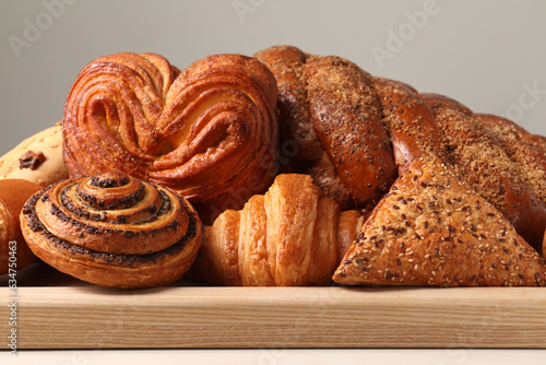 Different tasty freshly baked pastries on white table photo