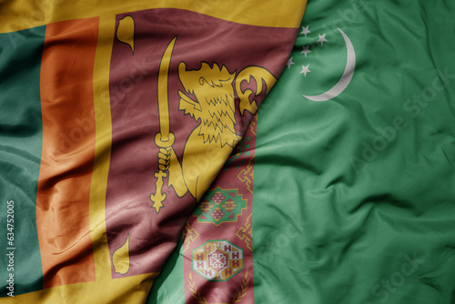 big waving realistic national colorful flag of sri lanka and national flag of turkmenistan .