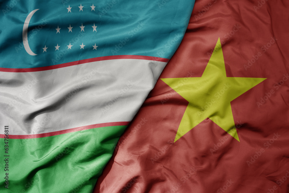 Fototapeta premium big waving realistic national colorful flag of uzbekistan and national flag of vietnam .