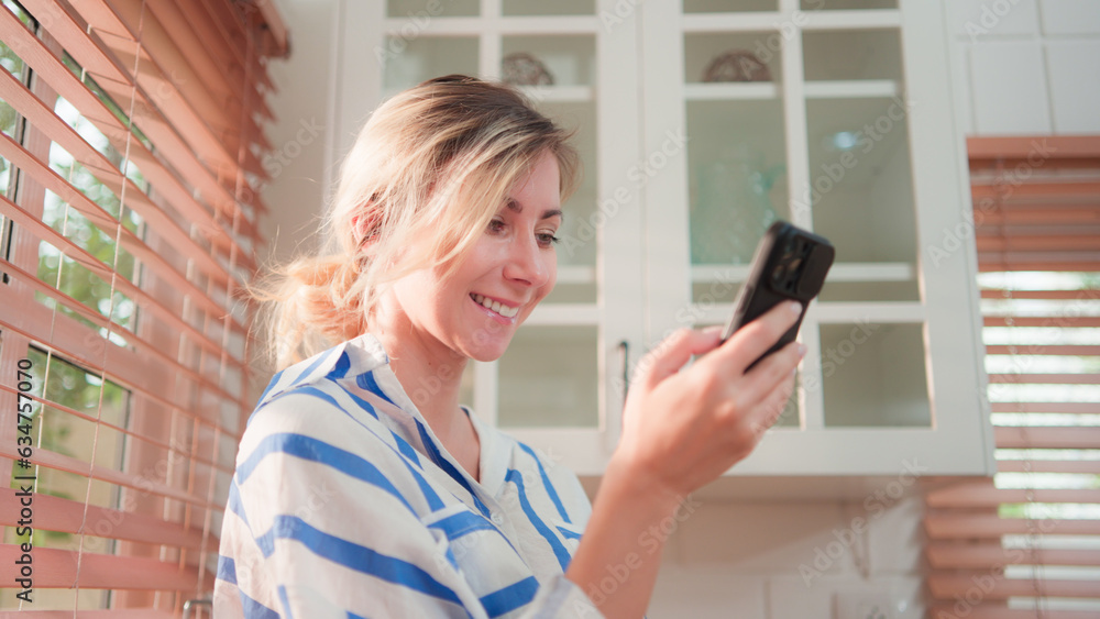 Young Caucasia female hand holding mobile phone at home. Beautiful Girl using smartphone touchscreen for watching check email, browsing internet, app, social media online. Digital technology concept. Young Caucasia female hand holding mobile phone at home. Beautiful Girl using smartphone touchscreen for watching check email, browsing internet, app, social media online. Digital technology concept.