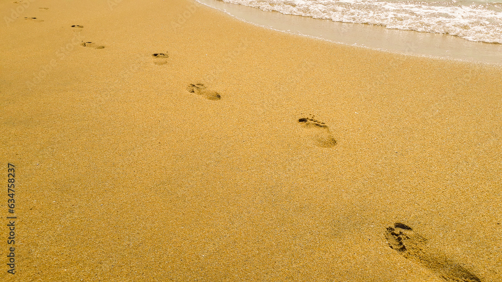 Human footprint on the sand at the beach background with copy space. Beach, wave and footsteps.
Human footprint on the sand at the beach background with copy space. Beach, wave and footsteps.