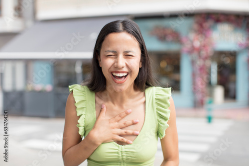 pretty hispanic woman laughing out loud at some hilarious joke, feeling happy and cheerful, having fun Free Download pretty hispanic woman laughing out loud at some hilarious joke, feeling happy and cheerful, having fun - GFXLoad