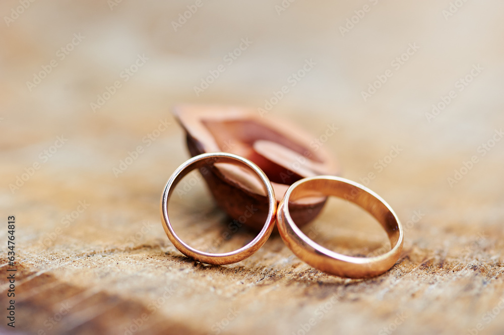 Couple of gold wedding rings on wooden background Couple of gold wedding rings on wooden background