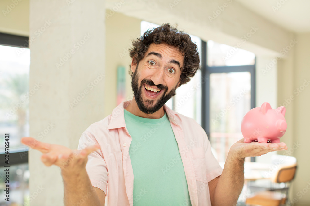 Fototapeta premium crazy bearded man smiling happily and offering or showing a concept. piggy bank concept