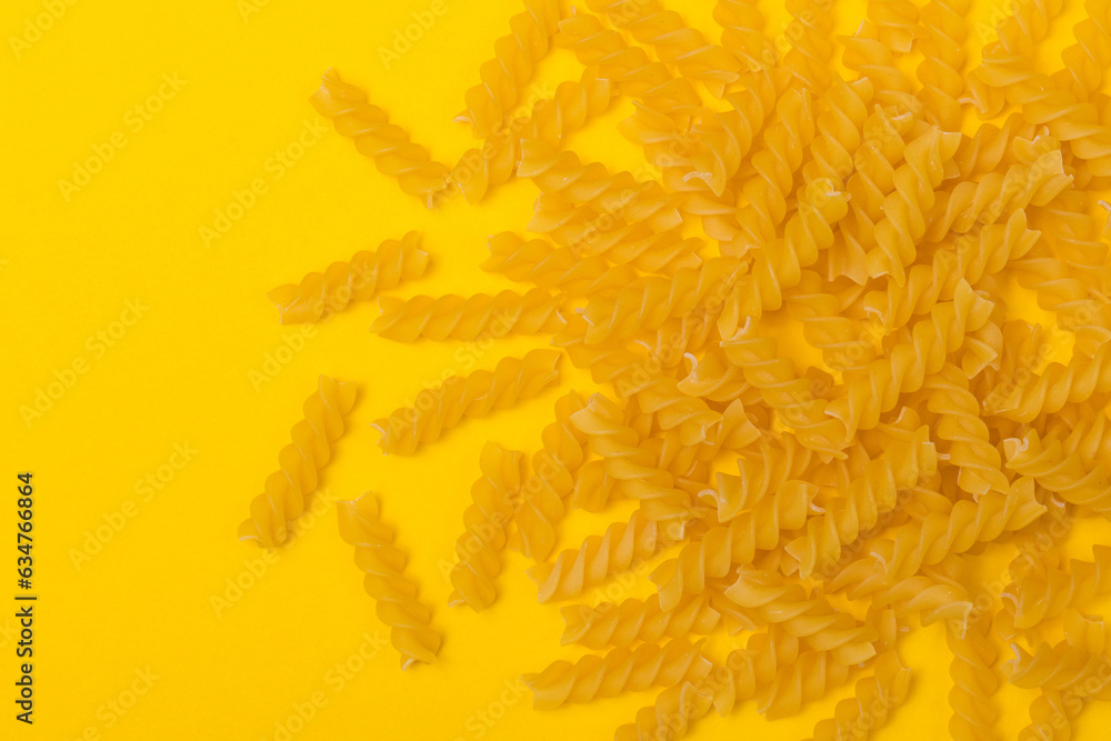 Heap of pasta on yellow background with copy space. Close-up. Top view. Heap of pasta on yellow background with copy space. Close-up. Top view.