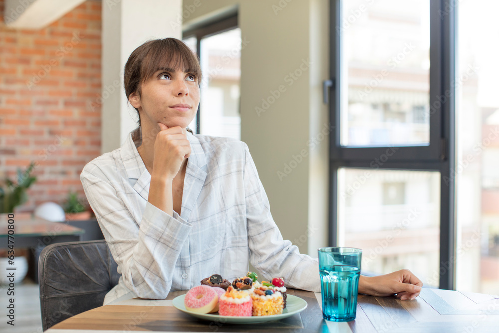 young pretty woman smiling with a happy, confident expression with hand on chin. home made cakes concept young pretty woman smiling with a happy, confident expression with hand on chin. home made cakes concept
