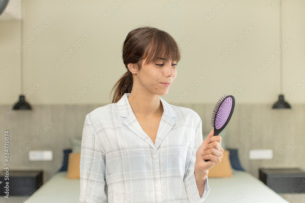young pretty woman smiling and looking with a happy confident expression. hair comb concept young pretty woman smiling and looking with a happy confident expression. hair comb concept